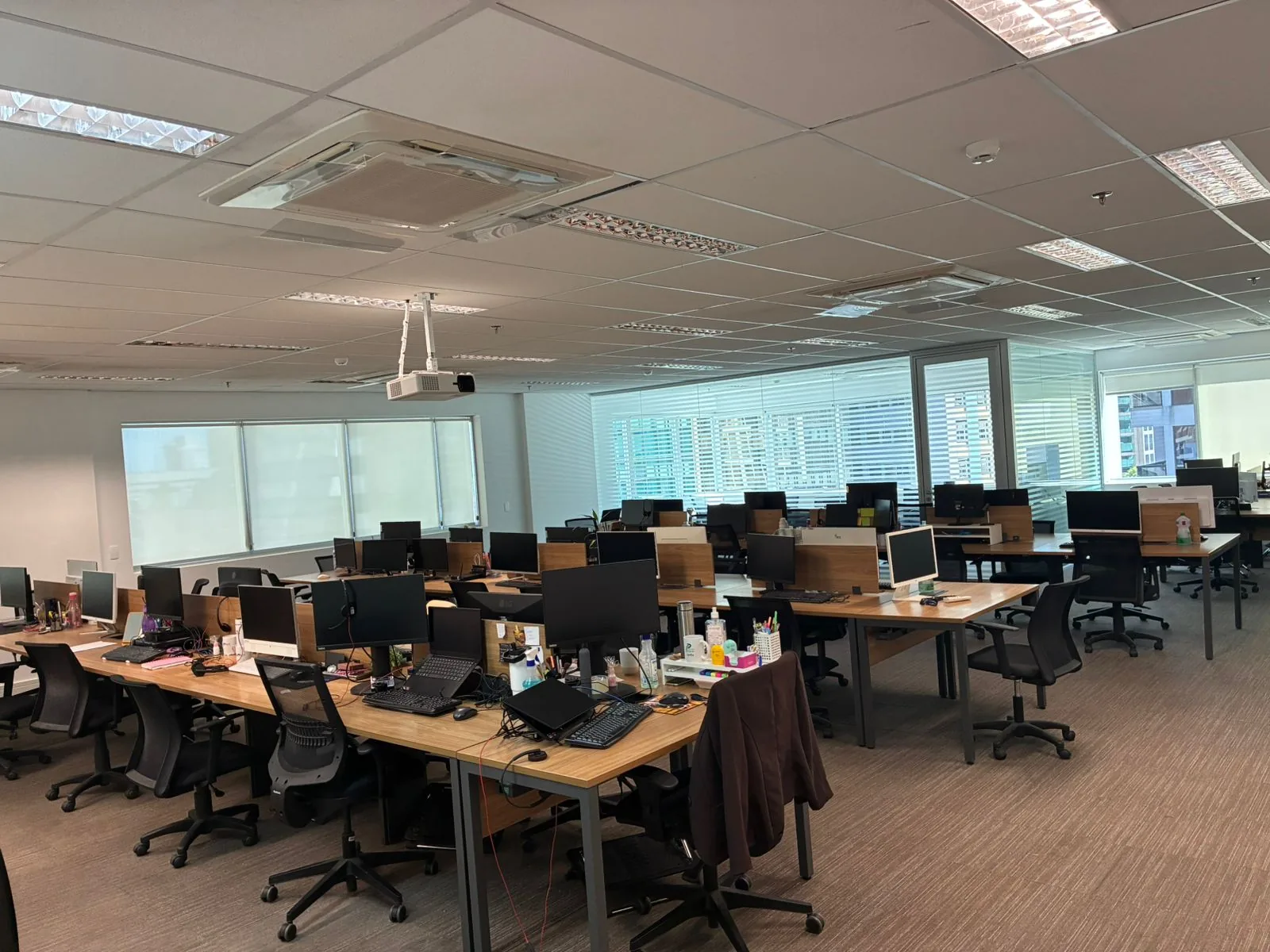 Escritório da Precatório Fácil na Alameda Santos, São Paulo: estações de trabalho, monitores e grandes janelas com luz natural